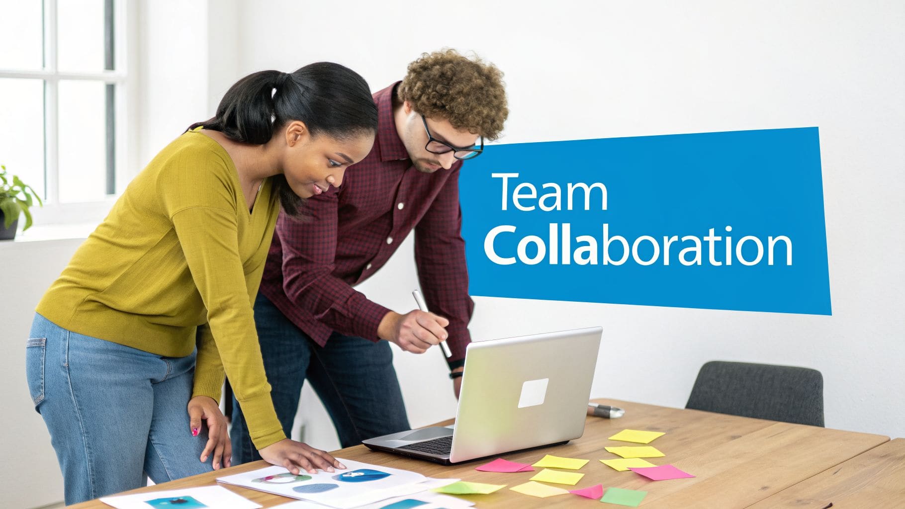 Two diverse colleagues collaborating and discussing ideas around laptop and papers with Team Collaboration text